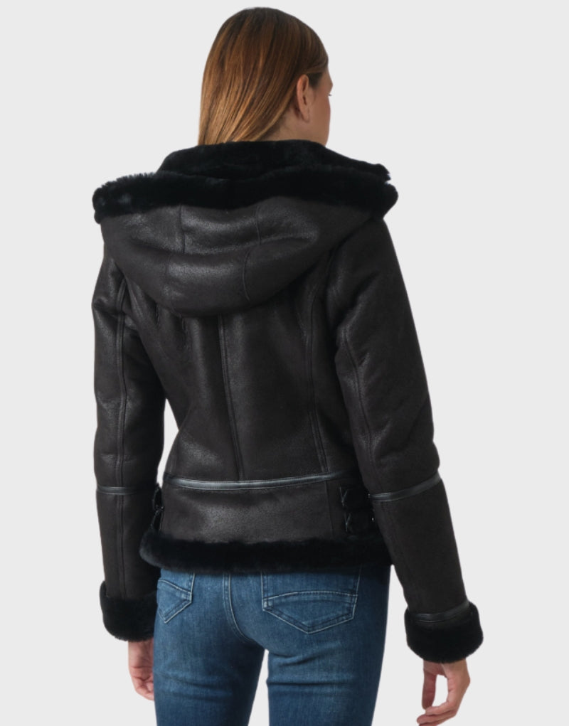 Stylish black sheepskin jacket with faux shearling lining, hooded design, and leather waist detailing—ideal for cold-weather outfits and layering.