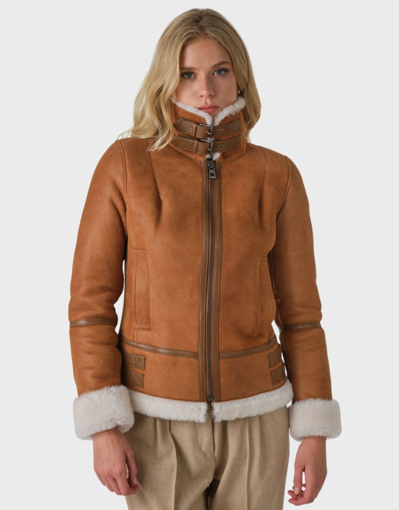 Women's tan sheepskin leather shearling jacket with a high buttoned collar, plush white fur lining, zip-up front, and adjustable cuffs - ideal for winter fashion.