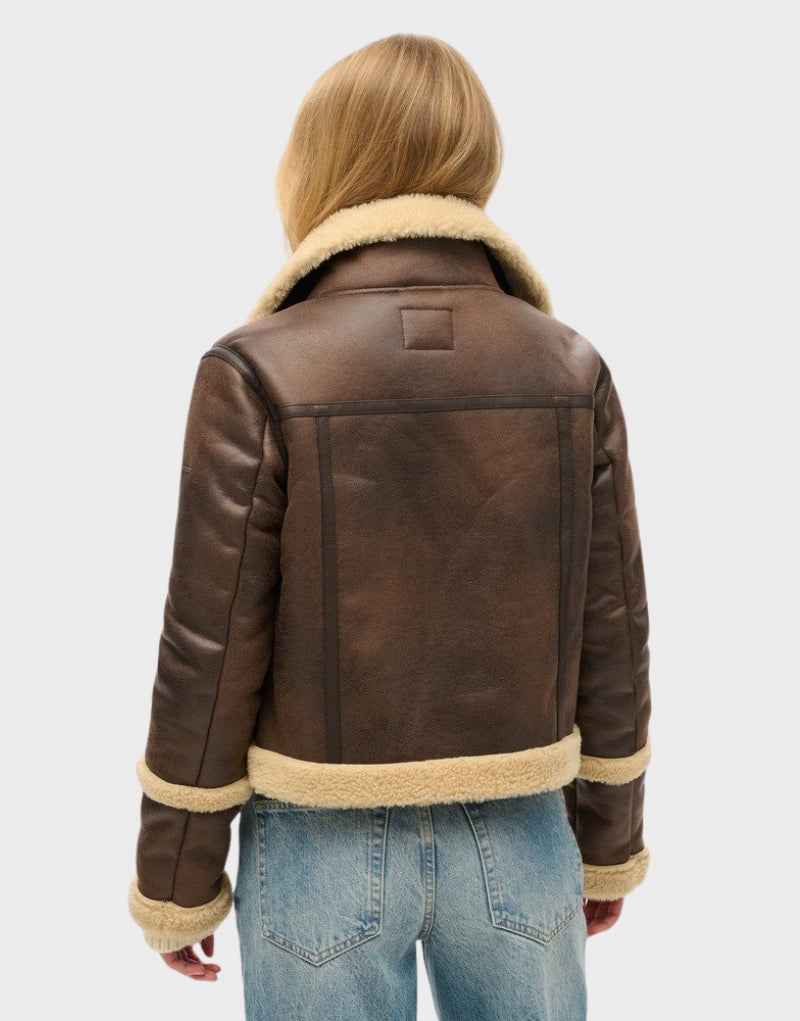 Back view of a women's cropped leather shearling jacket showcasing fur-lined cuffs, collar, and hem.