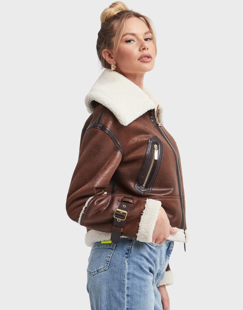 Women's brown cropped shearling aviator jacket with plush white fur collar, zip-up front, and adjustable cuffs perfect for winter warmth and style.